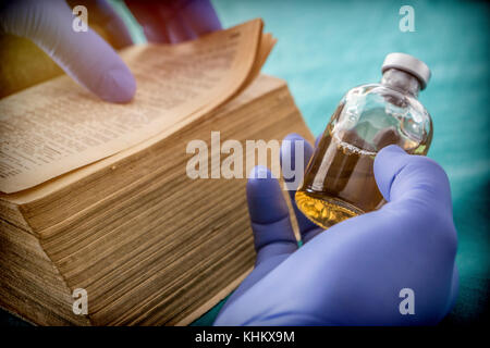 Doctor reading book of old medicine, conceptual image Stock Photo