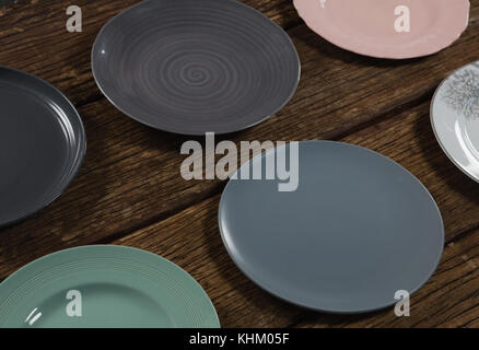 Close-up of various empty plates on wooden plank Stock Photo