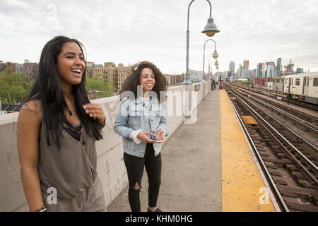 Young women waiting at a train station in Queens, New York Stock Photo