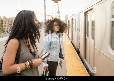 Young women waiting at a train station in Queens, New York Stock Photo