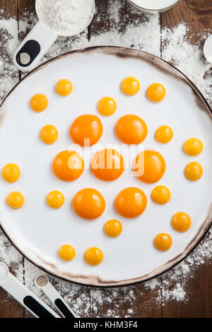 Raw egg yolks on white plate Stock Photo