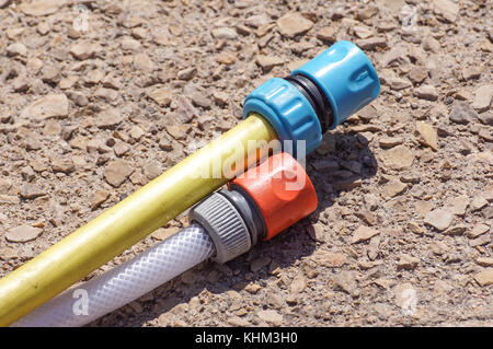 hose pipe and coupling on ground - selective focus on the front Stock Photo