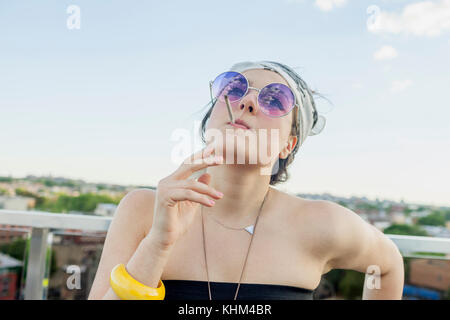 Young woman smoking on a rooftop Stock Photo
