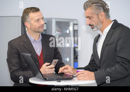 businessmen having tea in office after meeting Stock Photo