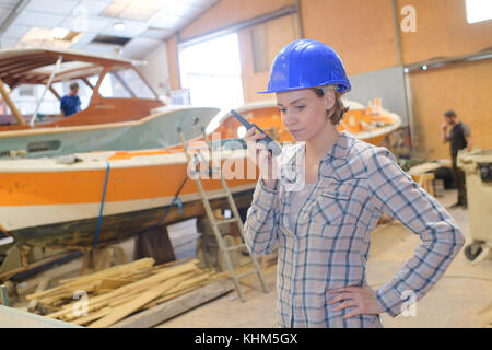 woman with a walkie-talkie and a helmet Stock Photo