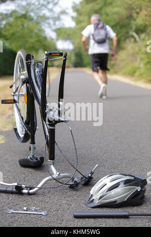 cyclist leaving his wrecked bicycle Stock Photo