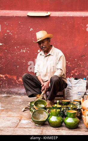 OAXACA MEXICO- DEC 7, 2015: Old man selling typical handicraft pottery in a market in Oaxaca on Dec 7, 2015, Mexico. Stock Photo