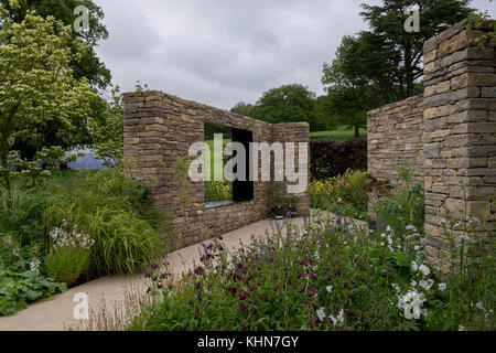 Walls shelter quiet, secluded area with plants in country style garden - Wedgewood Garden, RHS Chatsworth House Flower Show, Derbyshire, England, UK. Stock Photo