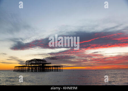 Brighton, UK. Starling murmurations at sunset over Brighton's derelict west pier. Stock Photo