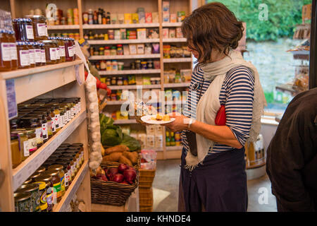 A woman shopper at the locally owned and managed Cletwr Cafe and community shop, Tre'r Ddol, Ceredigion Wales UK