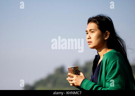 Human hand holding a brown cup of coffee.hot drink in paper cup. Stock Photo