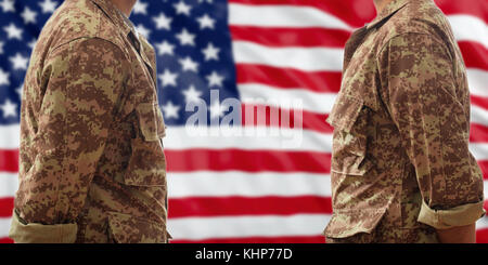 Soldiers in American military digital pattern uniforms, standing on a USA flag background Stock Photo