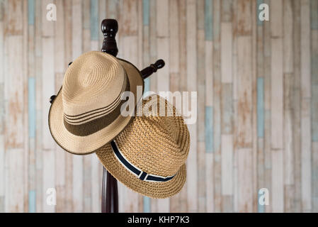 Straw hat hanging on wooden hanger.clothing accessories and travel concept Stock Photo