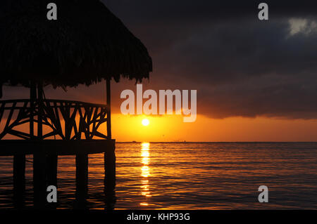 Sunset, cloud and hut on the sea shore in Carribean coast of Guatemala Stock Photo