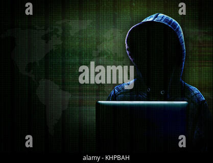 Unknown computer hacker with hood committing cyber crime with background data and world map in dramatic lighting with copy space. Stock Photo