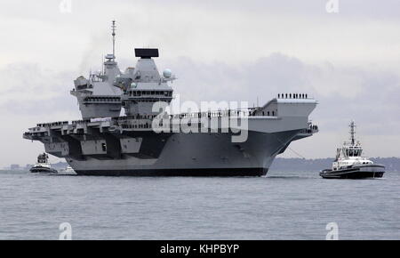 AJAXNETPHOTO. 16TH AUGUST, 2017. PORTSMOUTH, ENGLAND. - ROYAL NAVY'S BIGGEST WARSHIP SAILS INTO HOME PORT - HMS QUEEN ELIZABTH, THE FIRST OF TWO 65,000 TONNE, 900 FT LONG, STATE-OF-THE-ART AIRCRAFT CARRIERS SAILED INTO PORTSMOUTH NAVAL BASE IN THE EARLY HOURS OF THIS MORNING, GENTLY PUSHED AND SHOVED BY SIX TUGS INTO HER NEW BERTH ON PRINCESS ROYAL JETTY. THE £3BN CARRIER, THE LARGEST WARSHIP EVER BUILT FOR THE ROYAL NAVY, ARRIVED AT ARRIVED AT HER HOME PORT TWO DAYS AHEAD OF HER ORIGINAL SCHEDULE.  PHOTO: JONATHAN EASTLAND/AJAX  REF: D171608 6781 Stock Photo