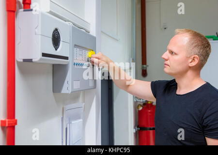 IT Engineer Opening Fire Panel In Server Room Stock Photo