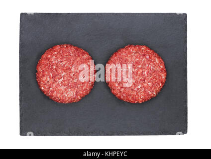 Raw fresh beef burgers on stone plate on white background Stock Photo