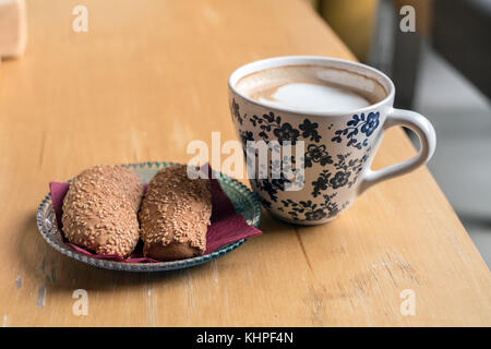 Cup of Hot Coffee with bread cookies served on wooden table Stock Photo