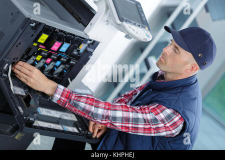 male trying to repair the office printer Stock Photo