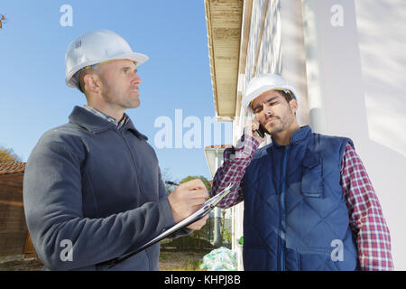 supervisors discussing at construction site against clear sky Stock Photo