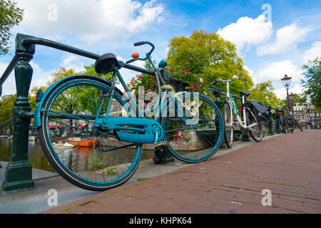 Traditional dutch bicycle parked on canal in Amsterdam Stock Photo