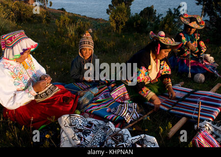 Village of Llachón, Capachica Peninsula, near Puno, Peru. Several women in Llachón engaged in the work of weaving the colorful clothes with which to d Stock Photo