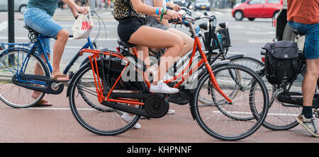 ROTTERDAM, HOLLAND - AUGUST 24, 2017; Street scene cyclists passing letterbox slot image of wheelsand legs only Stock Photo