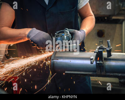 Use of angular grinder in a metalwork factory. Stock Photo