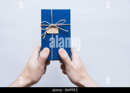 Blue gift box in male hands on a white background Stock Photo