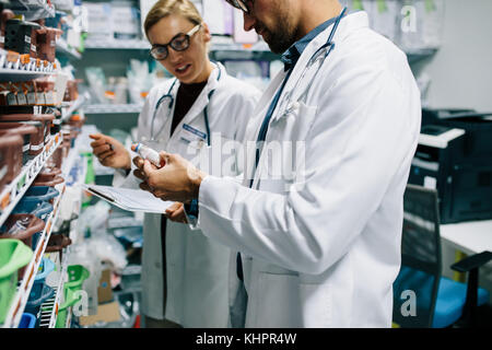 Two chemist working in pharmacy drugstore. Male and female pharmacists checking inventory at pharmacy. Stock Photo