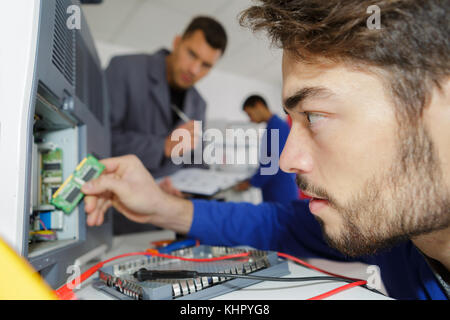technician fitting component into computer Stock Photo