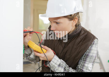 female electrician testing a wall socket Stock Photo