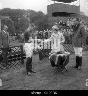 12/05/1963. Queen Elizabeth II presents the Royal Windsor Horse Show Cup to the Duke of Edinburgh who, as captain of Windsor Park, had helped defeat Bucket Hill in the final on Smith's Lawn, Windsor Great Park. The Royal couple will celebrate their platinum wedding anniversary on November 20. Stock Photo