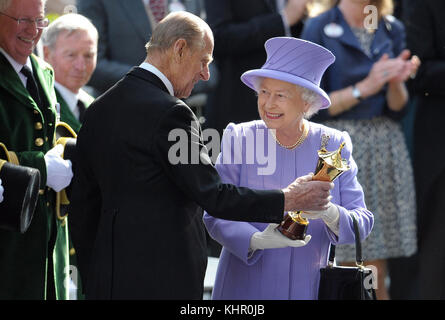 22/06/2012. Queen Elizabeth II receives a trophy from the Duke of Edinburgh after her horse Estimate won the Queen's Vase during day four of the 2012 Royal Ascot meeting at Ascot Racecourse, Berkshire. The Royal couple will celebrate their platinum wedding anniversary on November 20. Stock Photo