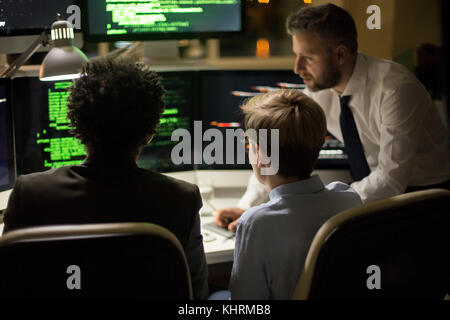 Creative team of programmers working together on brand new computer app while having informal meeting at spacious open plan office Stock Photo