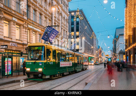 Helsinki, Finland - December 8, 2016: Tram Departs From A Stop On Aleksanterinkatu Street. Night View Of Aleksanterinkatu Street In Kluuvi District In