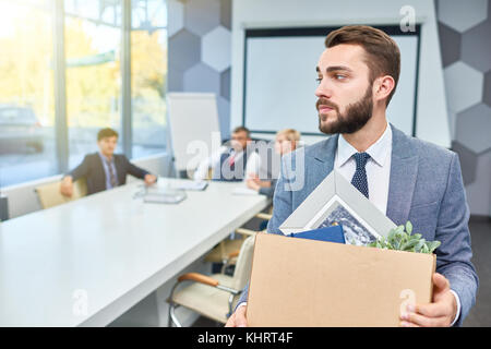 Portrait of sad bearded businessman holding box of personal belongings being fired from work, copy space Stock Photo