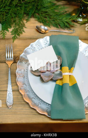 tableware, restaurant, dining concept. on the wooden table there is beautiful plate with original edge that is covered silver paint, all setting decorated of fabric napkin and light green succulent Stock Photo