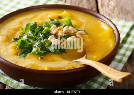 spicy Thai pumpkin soup with peanuts and cilantro close-up in a bowl on the table. horizontal Stock Photo