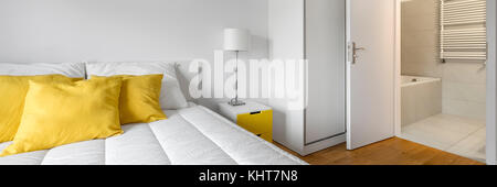 Modern, white bedroom with closet and private bathroom, panorama Stock Photo