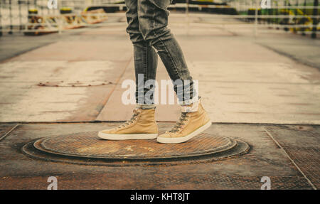 Male Legs In Grey Jeans And Canvas Boots Outdoor. Fashion Street Photo, color tone.