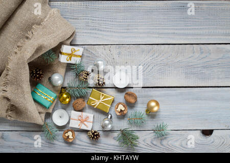 Christmas decorations in a sack on a white wooden surface Stock Photo