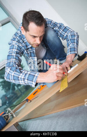 male carpenter uses measuring tape measure wood Stock Photo