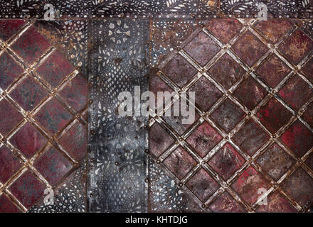 Geometric pattern in form of squares on old rusty metal surface and black painted stripes in top corners and in middle . Stock Photo