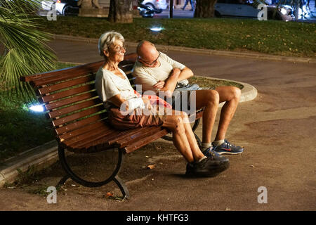 Monaco France 16 August 2017 : Homeless couple . Man is sleeping on a park bench in the city Stock Photo