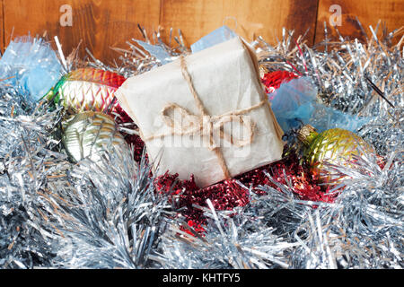 Small Handmade gift boxes in shiny tinsel on wooden background Stock Photo