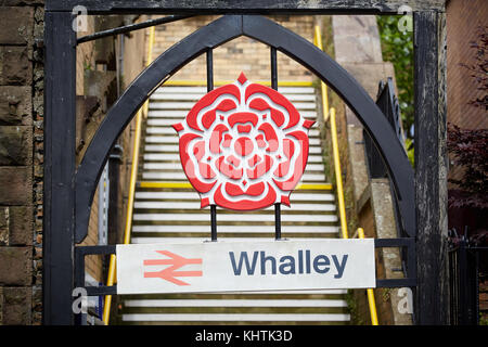 Whalley village in the Ribble Valley, Lancashire. Pictured Whalley railway station entrance, with a sign and the iconic Red Rose of Lancashire in the  Stock Photo