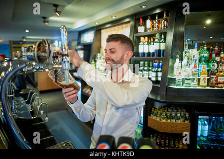 A barman pulling a pint at Marston's The Old Duke pub in Southport in Merseyside Stock Photo