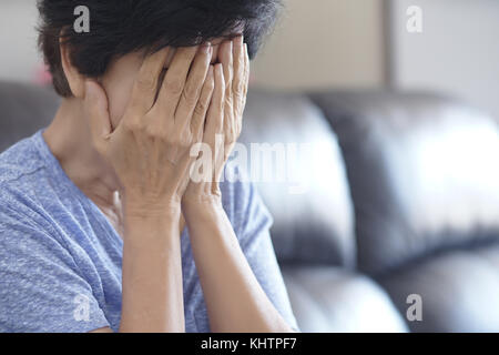 Elderly woman suffering from headache Depressed  at home Stock Photo